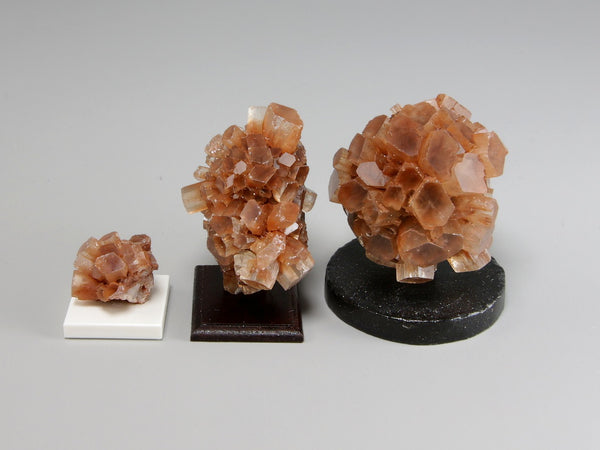 Side view, Three different sizes of aragonite crystal clusters on stands with a pencil for scale; dollhouse miniatures