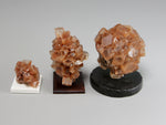 Side view, Three different sizes of aragonite crystal clusters on stands with a pencil for scale; dollhouse miniatures