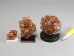 Three different sizes of aragonite crystal clusters on stands with a pencil for scale; dollhouse miniatures