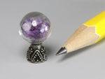 Tiny glass orb filled with amethyst chips