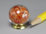 Tiny glass orb filled with carnelian chips