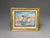 Framed miniature artwork of children playing on a beach with a gold frame.