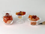 Tiny orange, red & yellow fire opal crystals in assorted 1:12 scale glass dishes.  Side view.